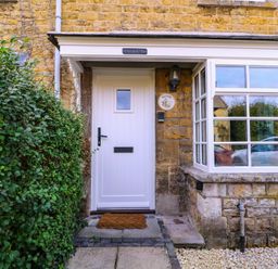 A front entrance with a door and window at Mallards in Bourton-On-The-Water