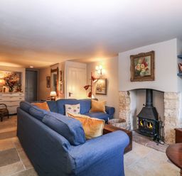 A living room with a fireplace and a sofa at Mallards in Bourton-On-The-Water