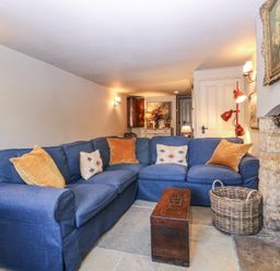 A living room with a blue sofa and a coffee table at Mallards in Bourton-On-The-Water