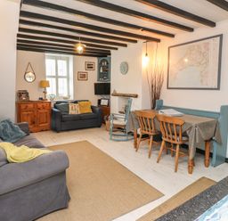A living room with a dining table and chairs at Menuchah in Criccieth