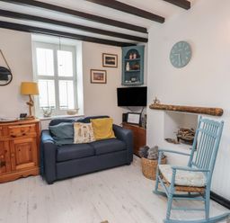 A living room with a sofa and a coffee table at Menuchah in Criccieth