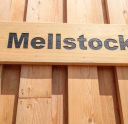 A wooden sign with the word Mellstock on a wooden wall at Mellstock in Nottington near Weymouth