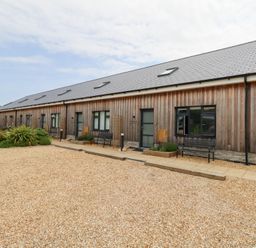 A wooden building with benches and gravel area at Durbyfield Nottington near Weymouth