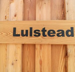 A wooden sign with the word Lulstead on a wooden plank background at Lulstead in Nottington near Weymouth