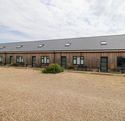 A wooden building with multiple doors and windows at Lulstead Nottington near Weymouth