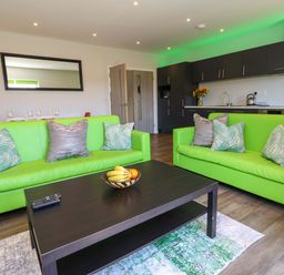 A living room with green couches and a coffee table at Overcombe Mill Nottington near Weymouth