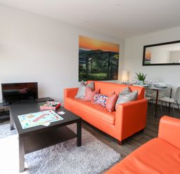 A living room with sofas, a coffee table, and a dining area at Corvesgate in Nottington near Weymouth