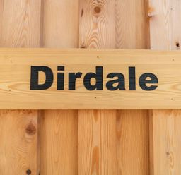 A wooden sign with the word Dirdale on a wooden wall at Dirdale in Weymouth