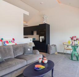 A living room with a sofa and a kitchen area at Ninky Nonk in Bristol