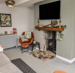 A living room with a fireplace and seating area at Country Retreat in Ponteland