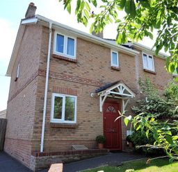 A brick house with a red front door and white windows at 1 Coppers Knapp Lyme Regis