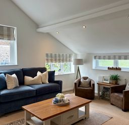 A living room with a sofa and armchairs at 11 The Gables in Lyme Regis