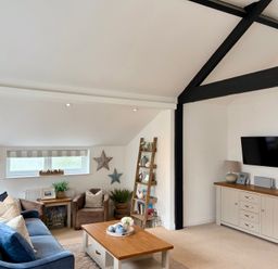 A living room with a sofa and television at 11 The Gables in Lyme Regis