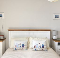 A bedroom with a bed framed by two bedside tables each with a lamp and two small framed pictures on the wall at 9 Bay View Court Lyme Regis