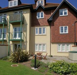 An exterior view of a residential building with balconies plants patio furniture and a storage shed at 2 Buckfields Lyme Regis