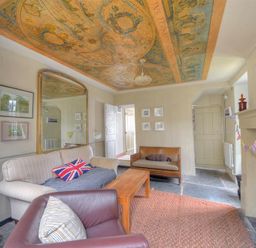 A living room with sofas a wooden coffee table a large mirror and a decorated ceiling at 10 Cobb Terrace Lyme Regis