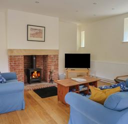 A living room with a sofa and television at Yard Cottage in Rousdon