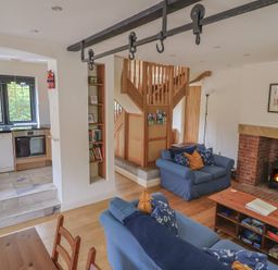 A living room with a fireplace and sofa at Yard Cottage in Rousdon
