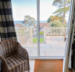 An indoor area with a chair and a view of the sea at Westhaven in Lyme Regis