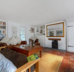 A living room with wooden furniture a bookcase and a fireplace at 24 Mill Green in Lyme Regis