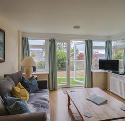 A living room with a sofa and coffee table at Penny Plot Cottage in Lyme Regis