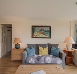 A living room with a sofa and coffee table at Penny Plot Cottage in Lyme Regis