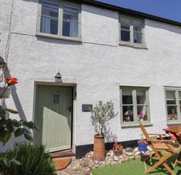 An exterior view of Cleve Cottage with door and garden in Lyme Regis