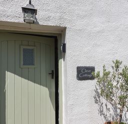 An entrance with a door and nameplate at Cleve Cottage in Lyme Regis