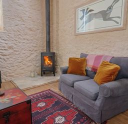 A living room with a sofa and fireplace at The Stone Barn in Bridport