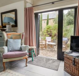 A living room with a chair and table at The Dairy in Bridport