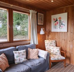 A snug with a sofa and armchair at 10 Pinewood Retreat in Pinewood