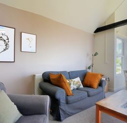 A living room with sofas and framed artwork on the wall at Bay View in Lyme Regis