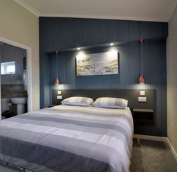 A bedroom with a bed and bedside shelves next to a window at Hazelwood 4 @ Pinewood Retreat in Pinewood