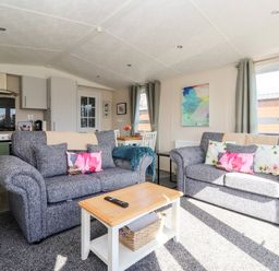 A living room with a sofa and dining table at Away Daze in Carnaby near Bridlington
