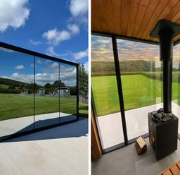A glass structure with wood stove and seating at Little Heaning in Cartmel