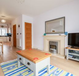 A living room with a coffee table rug fireplace and television at 6 Ocean Heights in Newquay