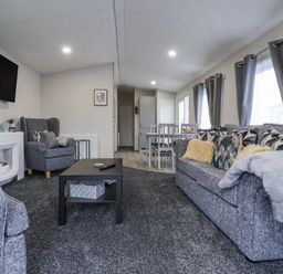 A living room with sofa and armchair at Lazy Daze in Carnaby near Bridlington