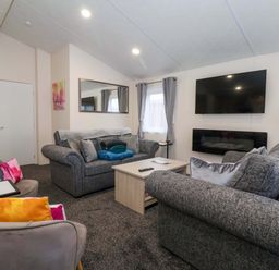 A living room with a sofa and television at Brighter Daze in Carnaby near Bridlington