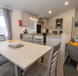 A kitchen with dining table and chairs at Brighter Daze in Carnaby near Bridlington