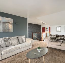 A living room with two sofas and a coffee table on a carpeted floor at The Old Coal Yard in Cemaes Bay