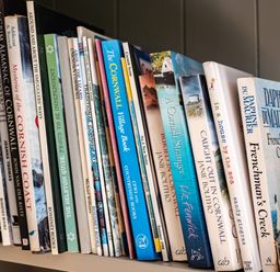 A close-up of a bookshelf with various books about Cornwall and novels at Chi Lowarth in Porthleven