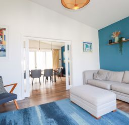 A living room with a sofa and artwork at Beach Haven in Perranporth