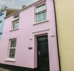 A pink building with a black door at Longmoor in Tenby