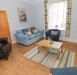 A living room with a sofa and armchair at Longmoor in Tenby