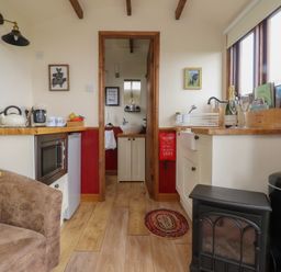 A kitchen with various appliances and furniture at The Journeyman Luxury Shepherds Hut in Barnoldswick