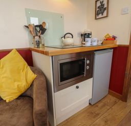 A kitchen area with a microwave and kettle at The Journeyman Luxury Shepherds Hut in Barnoldswick