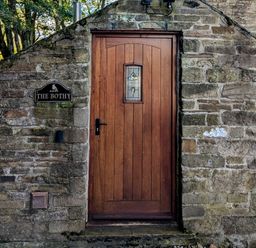 A wooden door set in a stone wall with a sign reading The Bothy at Bothy Nenthall near Alston