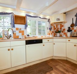 A kitchen with cabinets and a sink at Vi’s Valley View in Pentewan