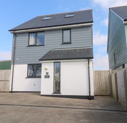 A two story house with a driveway and a wooden fence at Atlantic Reach in Marazion
