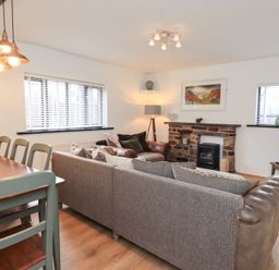 A living room with a sofa and dining table at Glen Lea in Giggleswick, Settle